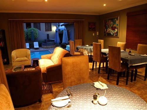 比勒陀利亚East View Guesthouse的客厅配有沙发、椅子和桌子
