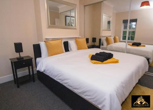 法恩伯勒Modern Luxury house in Farnborough的酒店客房 - 带两张带黄色枕头的床
