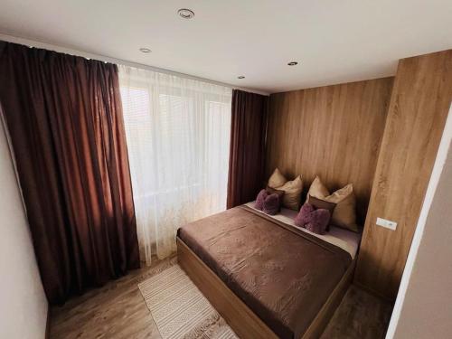 科希策Sparrow apartmens 3的小卧室配有带紫色枕头的床