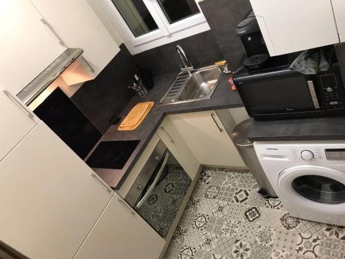布洛涅-比扬古Appartement 60 m², porte de Saint-Cloud的一个带水槽和洗衣机的小厨房