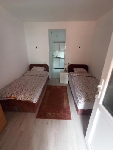 ProlomApartmani Lovcen的小型客房的两张床,配有镜子