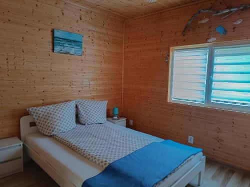 鲁斯诺沃Villa Natalia的卧室配有木墙内的一张床