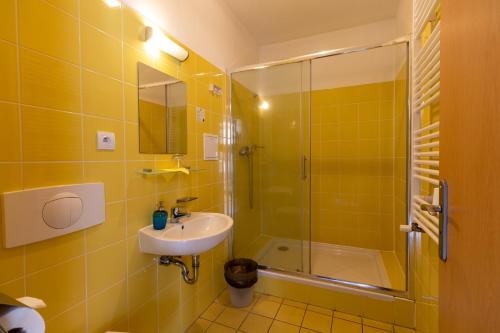 HoražďoviceHotel Prácheň的黄色的浴室设有水槽和淋浴