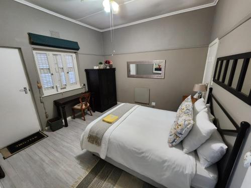 斯泰伦博斯Peony Luxury Room with Wifi and own entrance的卧室配有一张白色大床和一张书桌