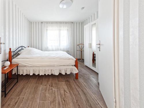 沙博伊茨Mein Strand Apartment的一间卧室配有一张床,铺有木地板