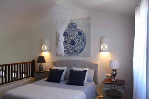 普拉亚布兰卡Apartamento Frida Faro Park的一间卧室配有床和蓝白色花瓶