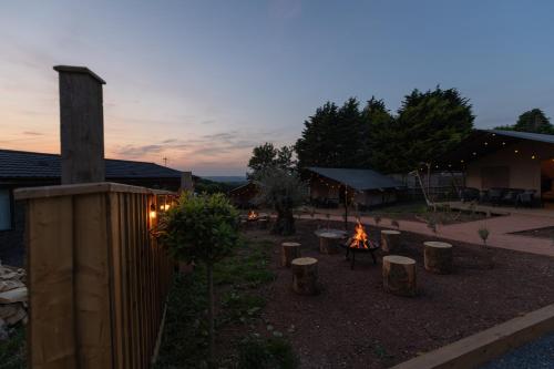 AbbotskerswellLuxury Glamping at Stags Head的一个带火坑的后院和一座建筑