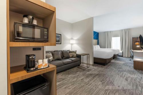 加拉廷Comfort Inn & Suites Gallatin - Nashville Metro的酒店客房设有一张沙发和一张床