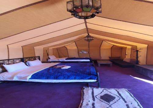 梅尔祖卡Luxury Desert Romantic Camp的帐篷内一间卧室,配有一张大床