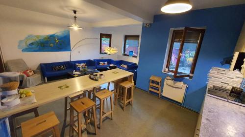 布加勒斯特Popcorn Hostel的客厅配有桌子和蓝色的墙壁