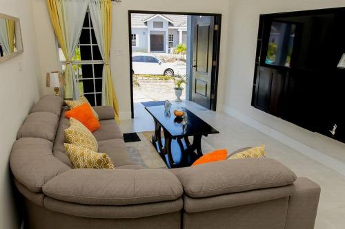 BoscobelModern & Spacious 2-BDRM/ Gated/Near Ocho Rios的客厅配有沙发和桌子