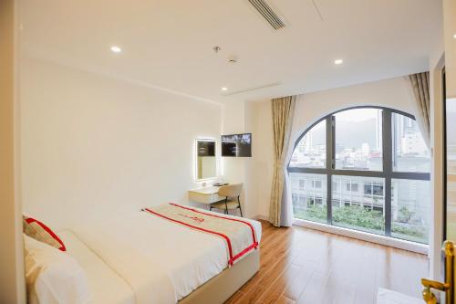 芽庄Kana Hotel Nha Trang的一间卧室设有一张床和一个大窗户
