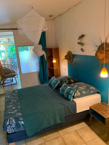 德赛Les Manguiers的一间卧室配有一张蓝色墙壁的床