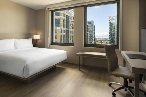 奥克兰AC Hotel by Marriott Oakland Downtown的酒店客房设有一张床、一张书桌和窗户。