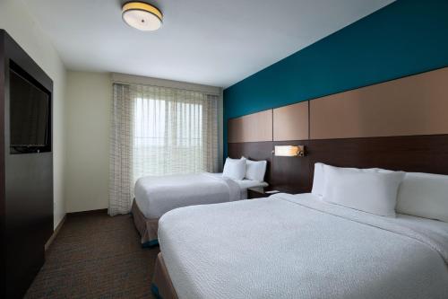 奥斯汀Residence Inn by Marriott Austin Southwest的酒店客房设有两张床和窗户。