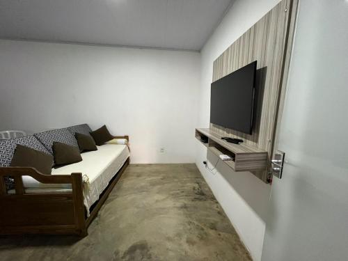 戈亚斯州上帕莱索Casa Esmeralda的一间卧室配有一张床和一台平面电视