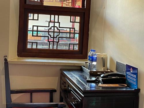 北京北京合德缘四合院酒店的一张桌子、一部电话和一扇窗户