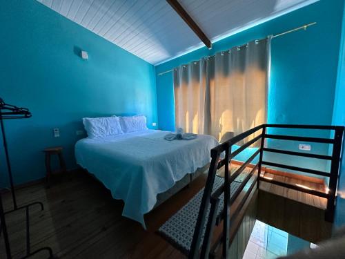 戈亚斯州上帕莱索Cantinho Santiago的一间蓝色卧室,配有一张床和一个阳台