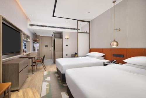 顺义北京顺义希尔顿惠庭酒店的酒店客房设有两张床和一台平面电视。