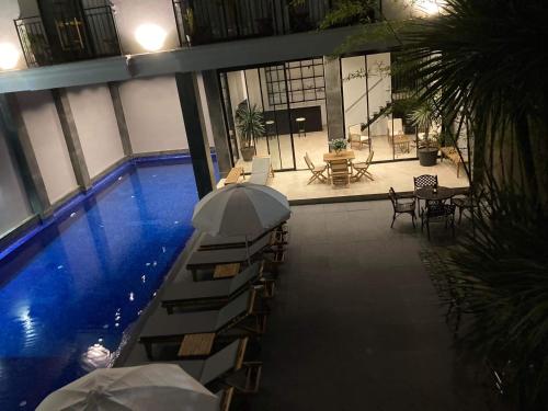 科布列季Hotel Homey Kobuleti的一座带遮阳伞的游泳池位于大楼旁