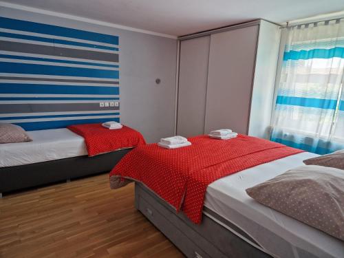 卢布尔雅那帕特里夏公寓的一间卧室配有两张红色棉被的床