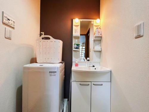 大阪Modern and Traditional Fusion Villa in Umeda 3-Min Walk to Subway Ideal for Families and Groups的一间带水槽和冰箱的小浴室