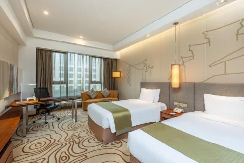 上海上海大华虹桥假日酒店的酒店客房配有两张床和一张书桌