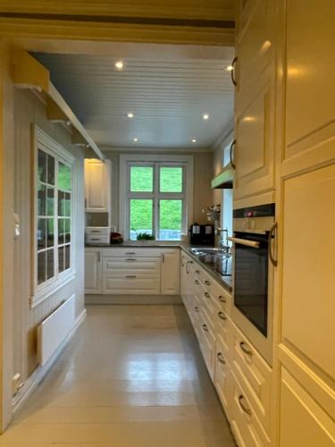SykkylvenMonshaugen Home的一间设有白色橱柜和窗户的大厨房