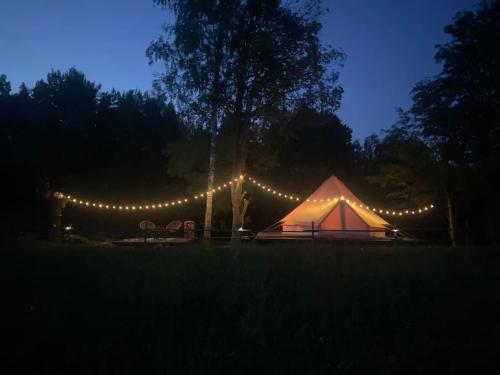 ÄhijärveKarula Stay Romantic and Luxurious Glämping in Karula National Park的帐篷在晚上点亮,灯光照亮