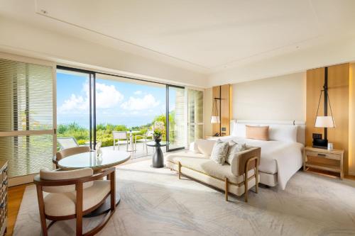 恩纳Halekulani Okinawa的一间卧室配有一张床、一张沙发和一张桌子