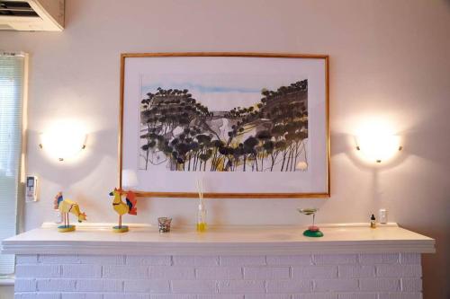 奥尔巴尼Asrama Albany的白色的 ⁇ ,有两盏灯,墙上有一幅画