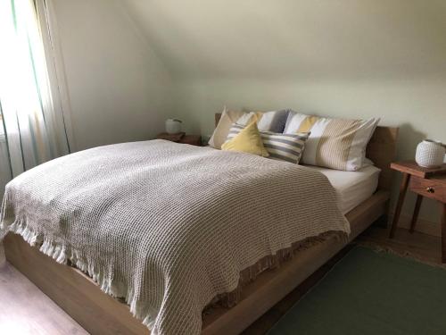 黑林山区舍瑙GartenFerienhaus "AnnaLuise"的一张带白色棉被和枕头的床