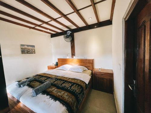 纳闽巴霍Cool Breeze Authentic Hotel Labuan Bajo Komodo的一间卧室配有一张大床和木制床头板