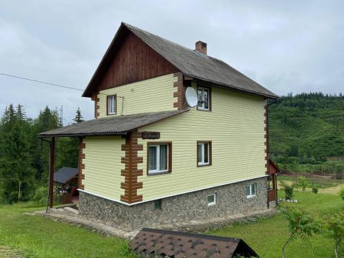 斯拉夫西克Родинна оселя的棕色屋顶的大型黄色房屋