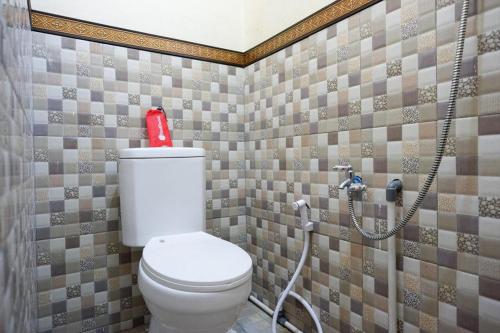 沃诺索博RedDoorz near Desa Wisata Tambi Dieng的浴室设有卫生间,配有红色的瓶子