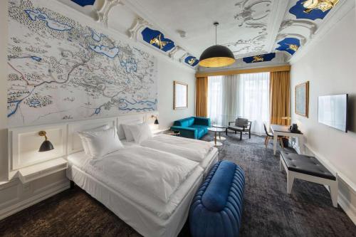 霍森斯Jørgensens Hotel的卧室配有一张白色大床和一张蓝色椅子