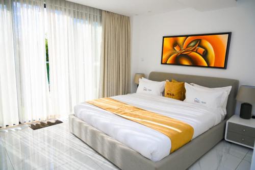 基加利White Stone Apartments Nyarutarama的一张大床,位于带大窗户的房间里