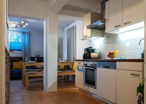 汉堡Spacious Apartment in urban location的一间厨房,配有白色橱柜和一间餐厅
