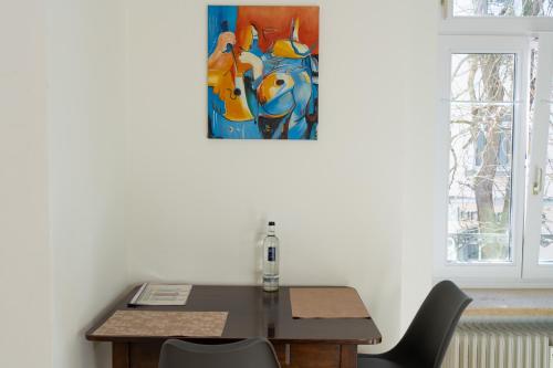 巴登-巴登菲林沃巴登巴登公寓的一张桌子和椅子,墙上挂着一幅画