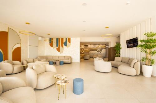巴尔奇克Royal Bay Resort - All Inclusive and Free beach accsess的大型客厅配有白色的椅子和桌子
