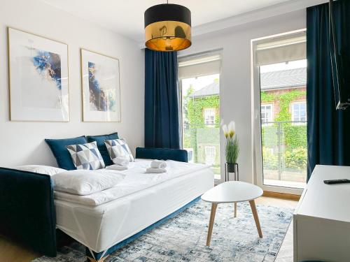 马佐夫舍地区新庄园DMK Blue Apartment near Warsaw-Modlin Airport的客厅配有白色沙发和蓝色窗帘