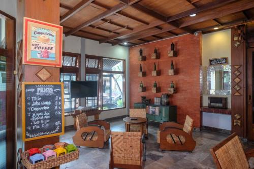 日惹Urbanview Hotel Syariah Wisnugraha by RedDoorz的餐厅设有壁挂式黑板和桌椅