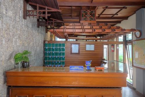 日惹Urbanview Hotel Syariah Wisnugraha by RedDoorz的一间酒吧,在房间内配有木台