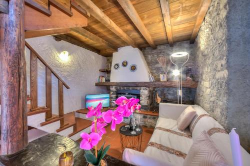 卢加诺Rustico Romantico Brè - Happy Rentals的客厅配有白色沙发和粉红色的鲜花