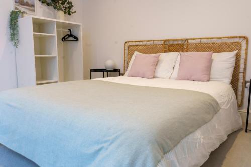 伦敦Gorgeous New 2 Bed Flat - 2 August House的卧室配有带粉色和白色枕头的大床