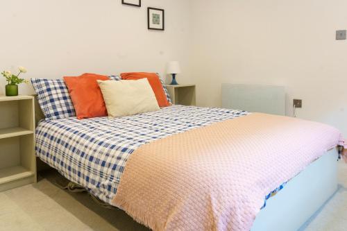 伦敦Gorgeous New 2 Bed Flat - 2 August House的一间卧室配有带色彩缤纷枕头的床