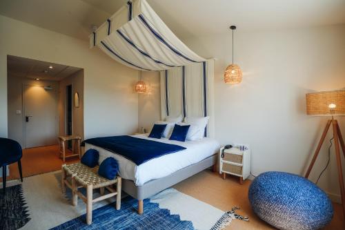 巴尔巴特尔Hôtel Le Noirmoutier的一间卧室配有一张带蓝色毯子的大床