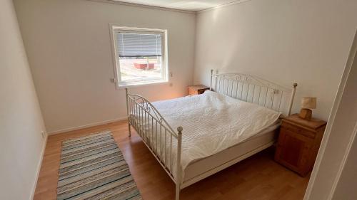 埃勒斯Ellös Holiday apartment的卧室配有白色的床和窗户。