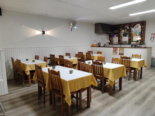 布拉加阿威尼达布拉格斯商业酒店的用餐室配有桌椅和黄色桌布
