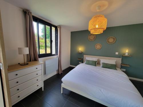 安德诺莱斯贝恩Les Cabanes de l'Airial Dune的卧室配有白色的床和绿色的墙壁